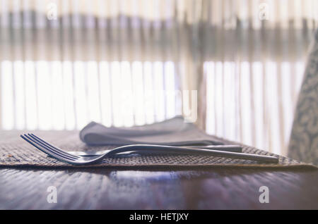 Fourchette et d'autres de la table sur la table de restaurant avec ambiance lumière arrière. Banque D'Images