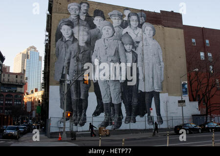 À Tribeca, Manhattan, JR, un artiste de rue, créé une murale photographique illustrant les enfants d'immigrants à Ellis Island. Banque D'Images