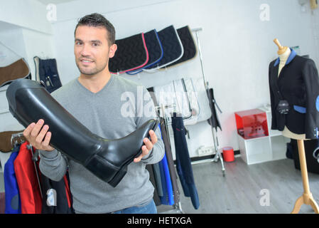 Dans l'homme shop holding bottes d'équitation Banque D'Images