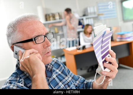 Man on cellphone holding tableaux peinture Banque D'Images