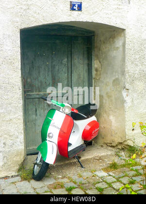 Vespa scooter dans les couleurs du drapeau italien stationné dans une entrée de porte et la publicité restaurant à proximité Banque D'Images