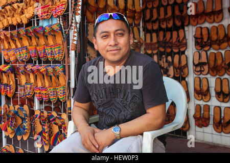 Street market trader sur la 5e Avenue, Playa Del Carmen, Riviera Maya, Mexique la vente de chaussures en cuir fait main et d'autres biens Banque D'Images