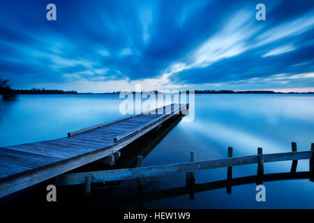 Une petite jetée sur un lac près d'Amsterdam aux Pays-Bas. Une vitesse d'obturation lente a été utilisé pour voir le mouvement des nuages dans le ciel. Photographié à da Banque D'Images