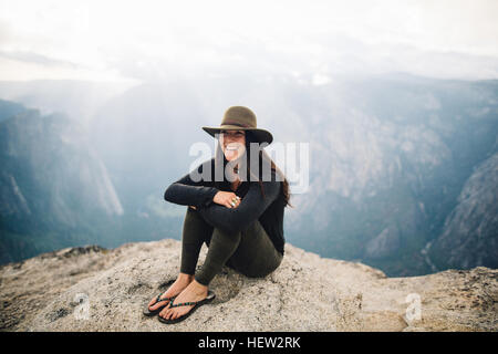 Portrait de jeune femme assise au sommet de la montagne, donnant sur Yosemite National Park, California, USA Banque D'Images