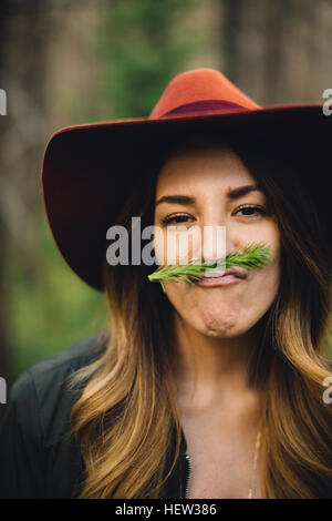 Portrait de femme avec le feuillage de la moustache tirant sur le visage, Rocky Mountain National Park, Colorado, USA Banque D'Images