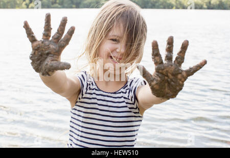 Portrait de fille avec mains boueuses dans river Banque D'Images