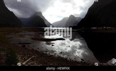 Ou bien humide, Milford Sound est incroyablement grand. Mitre Peak magnétise les photographes, et les falaises du fjord excite tant d'admiration et d'appréhension. Milford Sound est de loin le plus connu de tous les fjords et le seul qui peut être accessible par la route. Il est à environ 16km à partir de la tête du fjörd à la mer ouverte, ce qui signifie que les visiteurs peuvent facilement parcourir la longueur du fiord de la haute mer et de retour sur l'une des nombreuses options de croisière disponibles en 1½ à 2 heures Temps de croisière. Banque D'Images