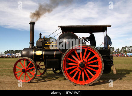Photographie d'un moteur de traction McLaren lors d'une foire nationale, présentant des machines à vapeur telles que des tracteurs et des moteurs d'époque. Les grosses roues rouges du moteur et l'atmosphère de rallye mettent en valeur les machines agricoles anciennes. Banque D'Images