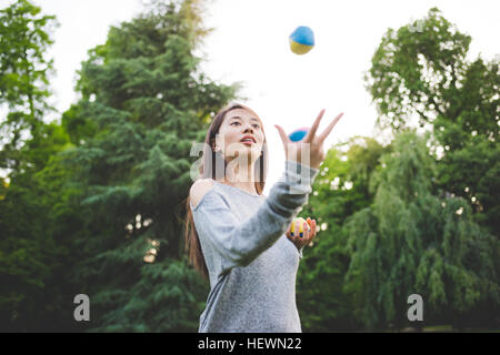 Jeune femme en balles de jonglage parc Banque D'Images