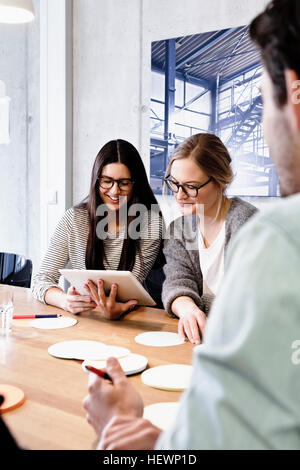 Collègues de séance dans la salle de conférence using digital tablet Banque D'Images