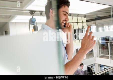Businessman in office using mobile phone Banque D'Images