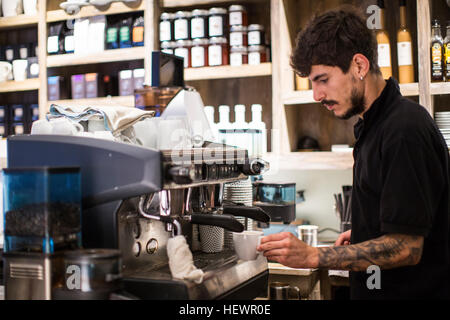 Jeune homme à l'aide de machine à café barista cafe Banque D'Images
