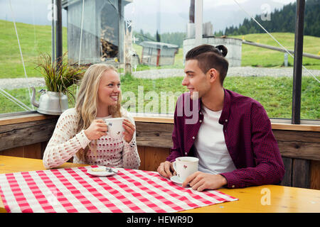 Jeune couple de boire du café et de parler à cafe Banque D'Images