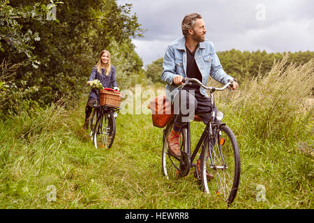 Couple à vélo le long chemin rural Banque D'Images