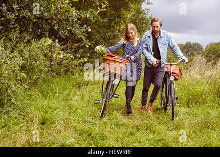 Deux cycles poussant le long chemin rural Banque D'Images