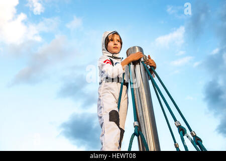 Garçon en costume d'astronaute à partir de haut de escalade Banque D'Images