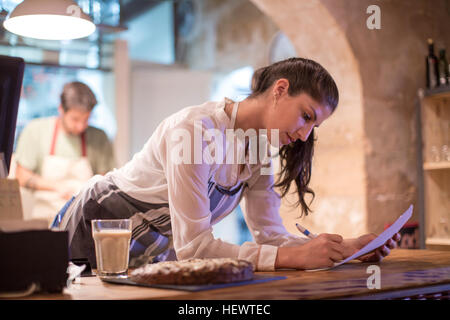 Propriétaires de restaurant working in kitchen Banque D'Images