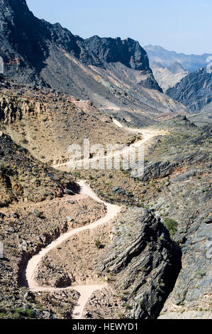 Un chemin de terre sinueux serpente à travers un col de montagne du désert. Banque D'Images