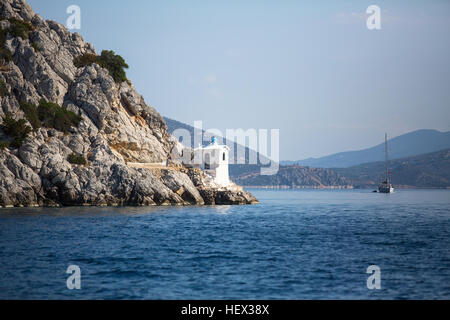 Phare sur les roches dans la mer Égée, Grèce. Banque D'Images