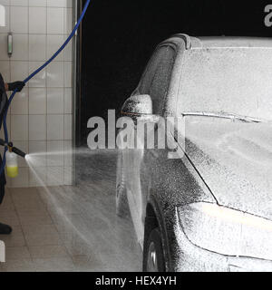 Laver le travailleur de la voiture sous une haute pression. Service de voiture. Banque D'Images