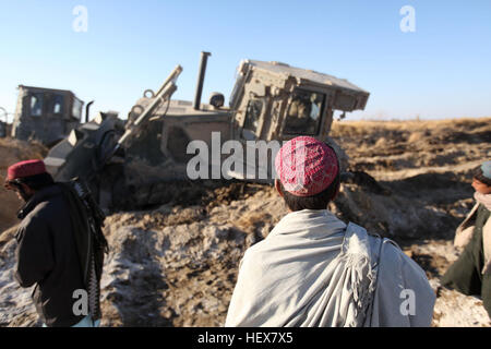 GARMSER, province de Helmand, République islamique d'Afghanistan - un groupe d'Afghans watch Marines avec le 1er Bataillon de Génie de Combat, 1 Division de marines (avant), tenter de récupérer les véhicules bloqués dans la région de Garmser, le 25 janvier 2011. Marines américains étaient sur le chemin pour construire une base de patrouille quand le terrain est devenu infranchissable. (U.S. Marine Corps photo par le Cpl. John M. McCall) Marines bataille AfghanistanE28099S363945 terrain DVIDS Banque D'Images