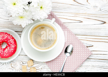 Café et beignes, fleurs sur fond de bois Banque D'Images