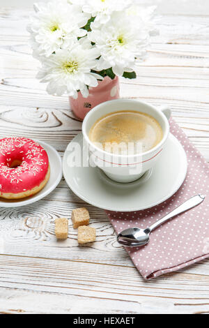 Café et beignes, fleurs sur fond de bois Banque D'Images