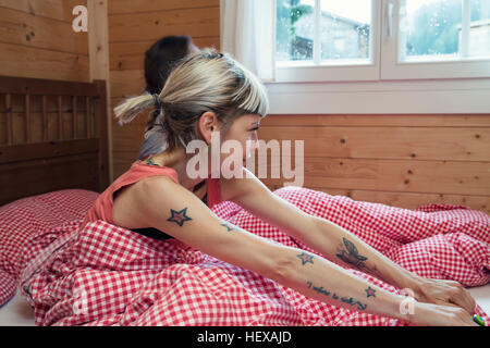 Deux femmes à la recherche d'une fenêtre de log cabin bed, Tyrol, Autriche Banque D'Images