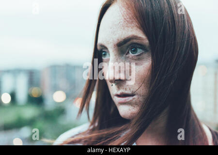 Close up portrait of young woman rousseur avec de longs cheveux rouges et nez piercing Banque D'Images