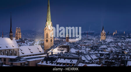La vieille ville avec des toits couverts de neige pendant la nuit, avec le clocher gothique lumineux tours, Zurich, Suisse. Banque D'Images