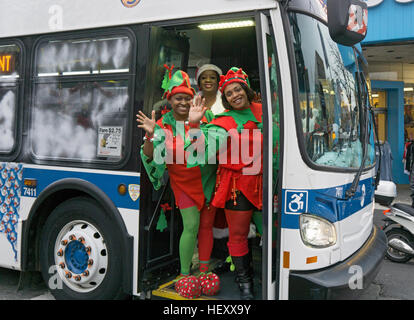 3 bénévoles de l'église habillés comme des elfes retour d'un party de Noël de charité pour les enfants. Au centre-ville de Flushing, Queens, New York. Banque D'Images