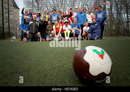 Les membres de la communauté des sans-abri et de charité bénévoles posent pour une photo de l'équipe d'avance sur leur rapport annuel Street Soccer match de football fête l'Écosse à Édimbourg. Banque D'Images
