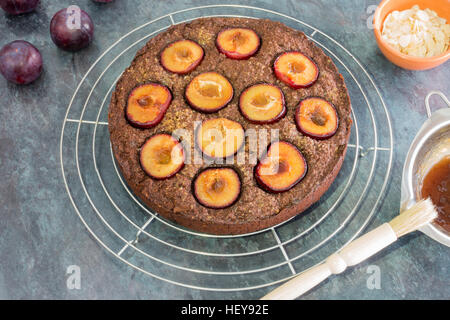 Sticky fraîchement cuits au four gâteau aux prunes sur grille de refroidissement Banque D'Images