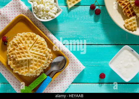 Le dîner ou le déjeuner pour les enfants - des gâteaux et des fruits, gaufres avec du fromage cottage et de crème sure. Les aliments pour enfants. Vue d'en haut. Banque D'Images