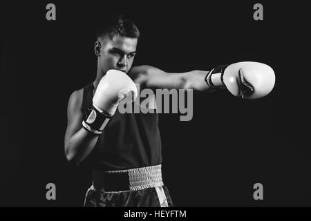 Jeune sportif boxer sur fond noir Banque D'Images