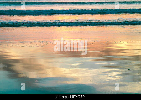Réflexions sur l'eau de plage au coucher du soleil Banque D'Images