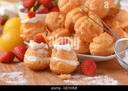 Profiteroles stuffed décoré avec des morceaux de fruits Banque D'Images