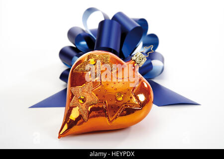 Golden Heart-shaped Christmas ornament avec un blue bow Banque D'Images