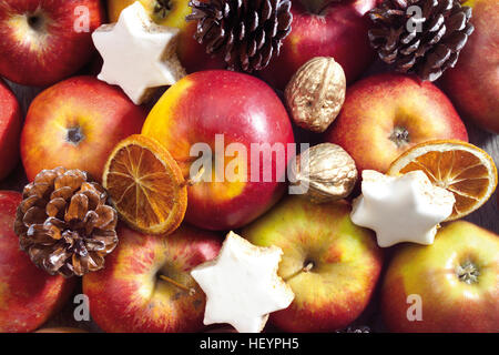 Plaque de Noël, format-remplissage : assortiment de pommes, noix, biscuits en forme d'étoiles, les oranges confites et des pommes de pin Banque D'Images