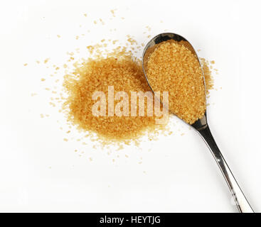 Cuillère en métal plein de sucre de canne brun avec pincée de sucre renversé autour d'isolé sur fond blanc, Close up, augmentation de la vue supérieure Banque D'Images