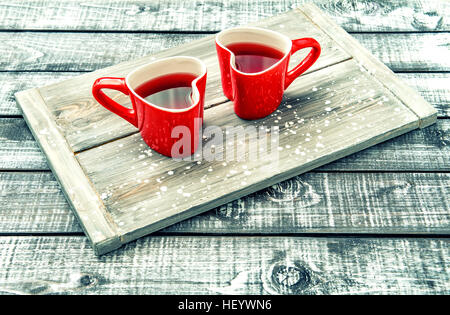 Tasses en forme de coeur rouge avec verre sur fond de bois rustique. Valentines Day concept. Tons style vintage photo Banque D'Images