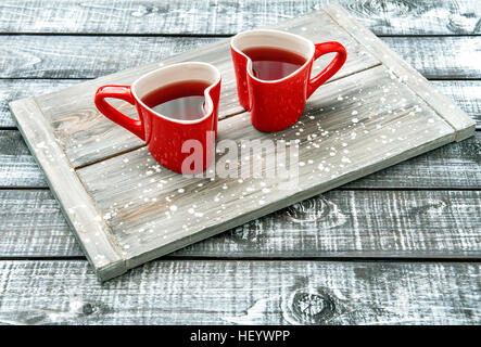 Tasses en forme de coeur rouge avec verre sur fond de bois rustique. Valentines Day concept Banque D'Images