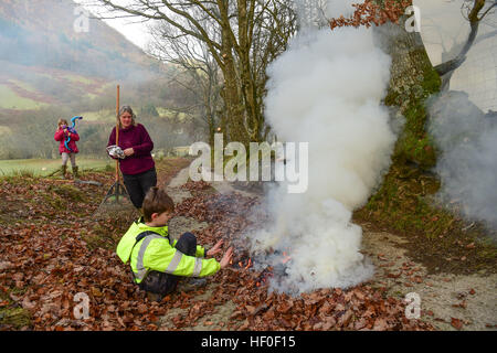 Llangynog, Powys, Wales, Royaume-Uni Le mardi 27 décembre 2016 par un froid glacial et matin dans Llangynog, un petit village au fond des montagnes Berwyn, au nord du Pays de Galles, KATE JEFFRIES, avec ses petits-enfants EMILY (8) et William (11), ramasser et brûler les dérives de feuilles sèches qui se sont accumulés sur la piste de sa ferme à distance après le coup de vent et des tempêtes au cours de Noël Photo © Keith Morris / Alamy Live News Banque D'Images