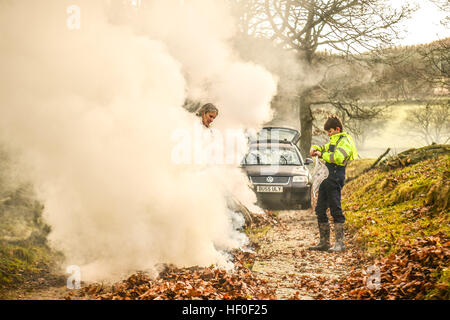 Llangynog, Powys, Wales, Royaume-Uni Le mardi 27 décembre 2016 par un froid glacial et matin dans Llangynog, un petit village au fond des montagnes Berwyn, au nord du Pays de Galles, KATE JEFFRIES, avec son petit-fils, William (11), ramasser et brûler les dérives de feuilles sèches qui se sont accumulés sur la piste de sa ferme à distance après le coup de vent et des tempêtes au cours de Noël Photo © Keith Morris / Alamy Live News Banque D'Images