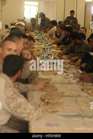 BASE d'opérations avancée, Delhi, province de Helmand, République islamique d'Afghanistan - le personnel avec l'ambassade du Royaume-Uni, 1er Bataillon, 3e Régiment de Marines ; 2e Kandak, 1ère Brigade, 215e Corps Canadien ; l'Armée nationale afghane ; et les aînés locaux manger le déjeuner pendant la visite officielle de l'Ambassade britannique ici, le 11 juin. L'ambassadeur britannique en Afghanistan, Sir William Patey a été informé des politiques, éducatives et d'infrastructure l'évolution de Garmsir depuis 2006. Les forces britanniques ont été les premiers à exploiter les forces de la coalition dans la région de Garmsir en 2006 et transféré l'autorité de la région pour le Corps des Marines en 2008. Le bataillon s Banque D'Images