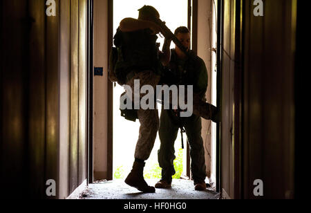 Le Sgt. Josh Sutherland, une entrée avec le membre de l'équipe de réaction militaire, police, Marine Corps Base Hawaii, coups de pied dans une porte pour effacer une chambre avec d'autres membre SRT Le Cpl. Alexander Williams lors de la formation au SRT Marine Corps Zone Formation soufflets, Hawaii, le 28 juin 2011. Bien que Sutherland remplit principalement les fonctions de formateur en chef de la division des mines et de l'article K9, il et d'une équipe de l'élément de la taille de la police militaire d'effectuer des fonctions de garantie que les membres SRT. Au-delà de leurs tâches régulières, ils sont prêts à répondre à des situations à haut risque qui peuvent survenir sur la base. Dégager l'araignée, et Banque D'Images