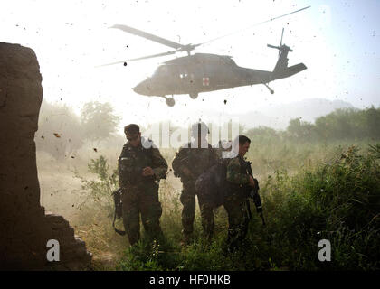 Les commandos afghans, avec l'Armée nationale afghane par le 3e Commando Le Kandak, protéger leurs visages à partir de la projection de débris après le chargement d'un commando blessés sur aUH-60 Black Hawk lors d'une opération de nettoyage du village dans le district de Zhari, le 6 juillet 2011, la province de Kandahar, Afghanistan. Les commandos, appuyés par les membres du service des opérations spéciales avec groupe de travail - Sud, trouvé et détruit plusieurs caches composé d'explosifs artisanaux et matériaux d'EEI, ainsi qu'une cache d'armes. Flickr - DVIDSHUB - Nous sortons de commandos, trouver les caches, à Kandahar (Image 1 de 10) Banque D'Images