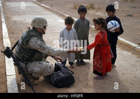 041031-Atkashat M-0036Y-046, l'Iraq (oct. 31, 2004) - Le Sergent d'artillerie. Jimmy Craig de Murfreesboro, Tennessee, affecté à la 4e Groupe des affaires civiles, les mains une boîte de crayons d'une jeune fille irakienne dans la ville de Atkashat, de l'Iraq. La 1 Division de marines est d'assurer la sécurité et les opérations de stabilisation (SASO) dans la province d'Al Anbar L'Iraq dans le cadre de l'opération Al Fajr (Nouveau Damn). U.S. Marine Corps photo par Lance Cpl. Andrew D. Young (libéré) US Navy 041031-M-0036Y-046 Sgt Tir. Jimmy Craig de Murfreesboro, Tennessee, affecté à la 4e Groupe des affaires civiles, les mains une boîte de crayons d'une jeune fille irakienne dans la ville de Banque D'Images