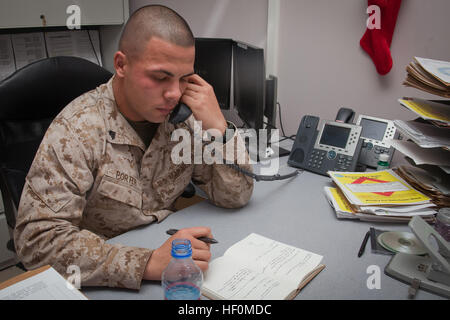 Le Cpl. Jake Porter, agent administratif sous-commandes pour la Force Belleau Wood et native de Fairfield, Texas, prend des notes qu'il s'entretient avec le secrétaire américain à la Défense Leon Panetta lors d'un appel téléphonique du 1er. Task Force Belleau Wood reçoit Marine Jour de l'appel téléphonique du ministre de la Défense 120101-M-DF801-007 Banque D'Images