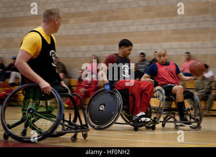 Le Cpl. Josue Barron, membre de l'équipe de l'Est, dribble la balle sous la pression défensive de l'équipe d'alliés à l'est par rapport aux alliés jeu de la Marine Corps 2012 Essais cliniques au Marine Corps Base Camp Pendleton, en Californie, le 18 février. Barron, qui a grandi en jouant au basket-ball dans la région de Cudahy, Californie, a dit qu'il aime être en mesure de continuer à jouer même après qu'il a perdu sa jambe gauche et l'œil dans un dispositif explosif blast en 2010. Barron est une des plus de 300 Marines blessés du régiment du guerrier blessé, en plus d'anciens combattants et alliés, sont en compétition dans le deuxième procès annuel, qui comprennent les pis Banque D'Images